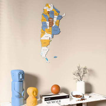 Flag colored Argentina wooden wall map on a beige wall above a console with figurines