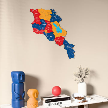 Flag colored Armenia wooden wall map on a beige wall above a console with figurines