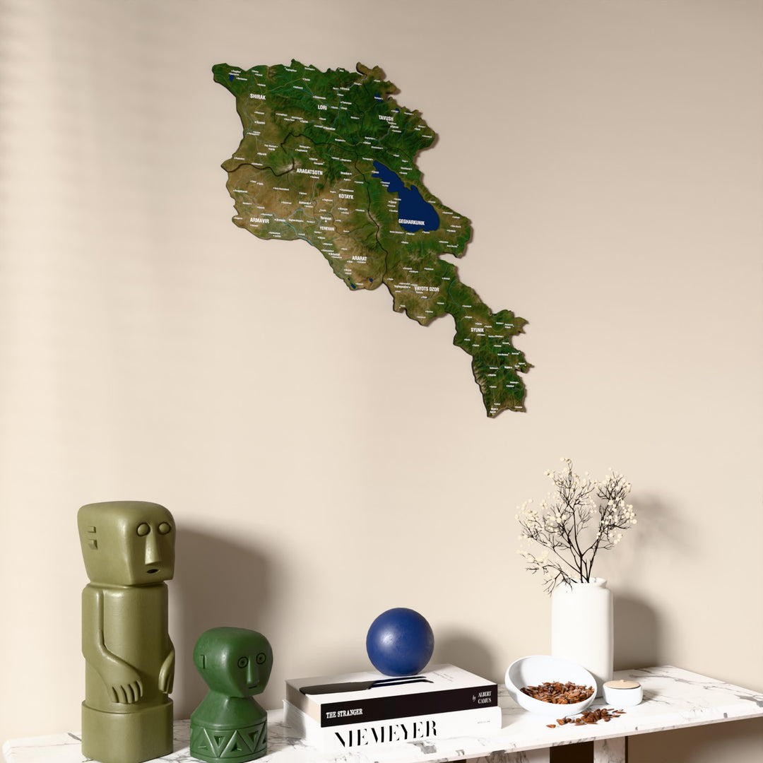Satellite Armenia wooden wall map on a beige wall above a console with figurines