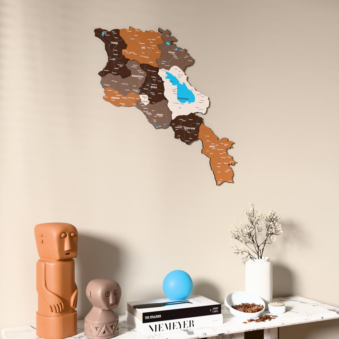 Soil Armenia wooden wall map on a beige wall above a console with figurines