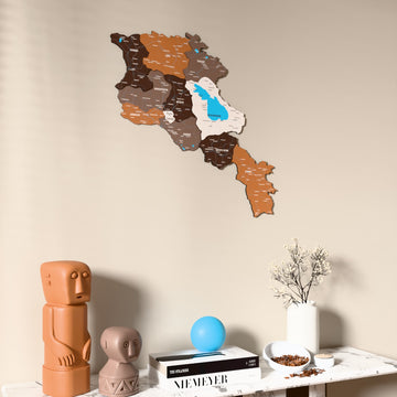 Soil Armenia wooden wall map on a beige wall above a console with figurines