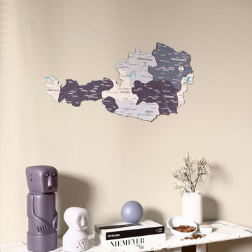 Nimbus Austria wooden wall map on a beige wall above a console with figurines