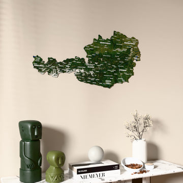 Satellite Austria wooden wall map on a beige wall above a console with figurines