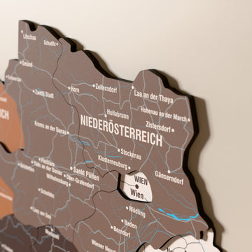 Close-up of the Soil Austria wooden wall map with layered regions and printed names