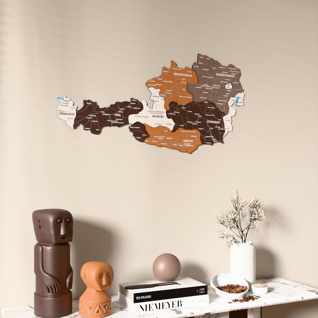 Soil Austria wooden wall map on a beige wall above a console with figurines