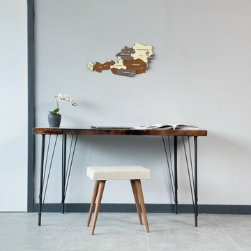 Austria wooden wall map above a resin-edged desk with an orchid, wide view