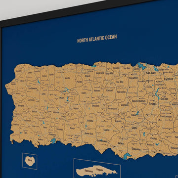 Close-up of the western half of a black-framed Puerto Rico cork map with municipality names and lakes