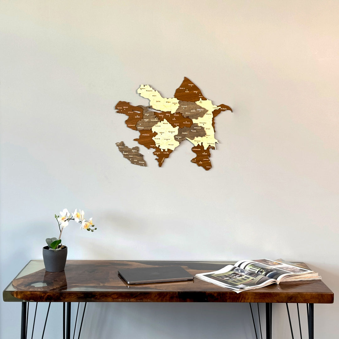 Azerbaijan wooden wall map on a white wall above a walnut resin desk with an orchid