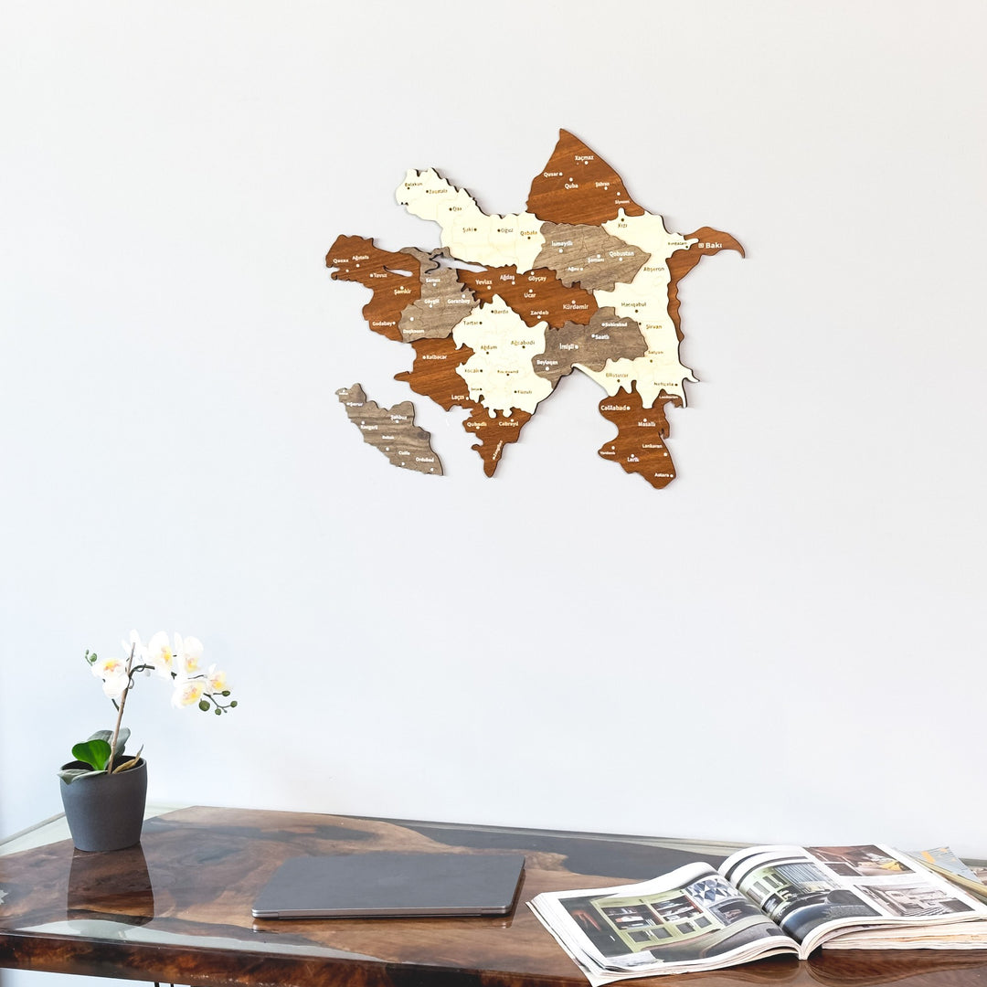 Azerbaijan wooden wall map above a walnut desk with a closed laptop