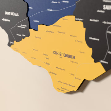 Close-up of the Flag colored Barbados wooden wall map with layered regions and printed names