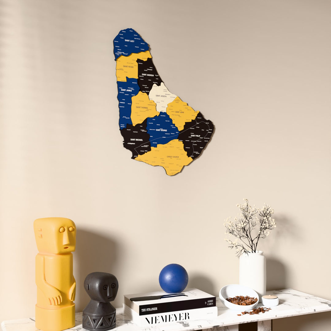 Flag colored Barbados wooden wall map on a beige wall above a console with figurines