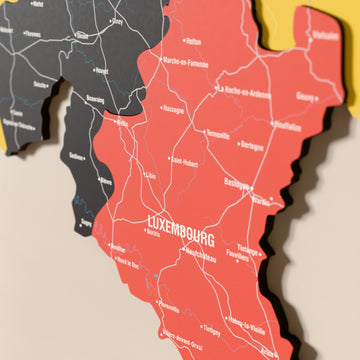 Close-up of the Flag colored Belgium wooden wall map with layered regions and printed names