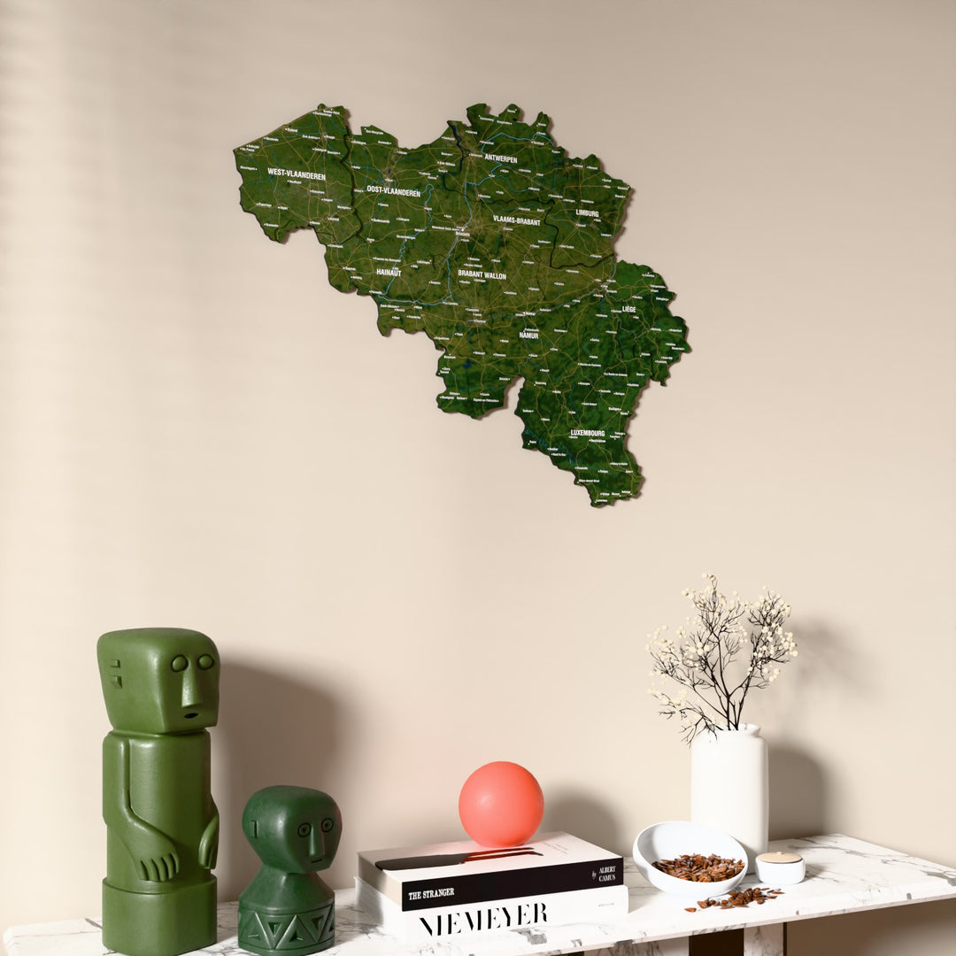 Satellite Belgium wooden wall map on a beige wall above a console with figurines