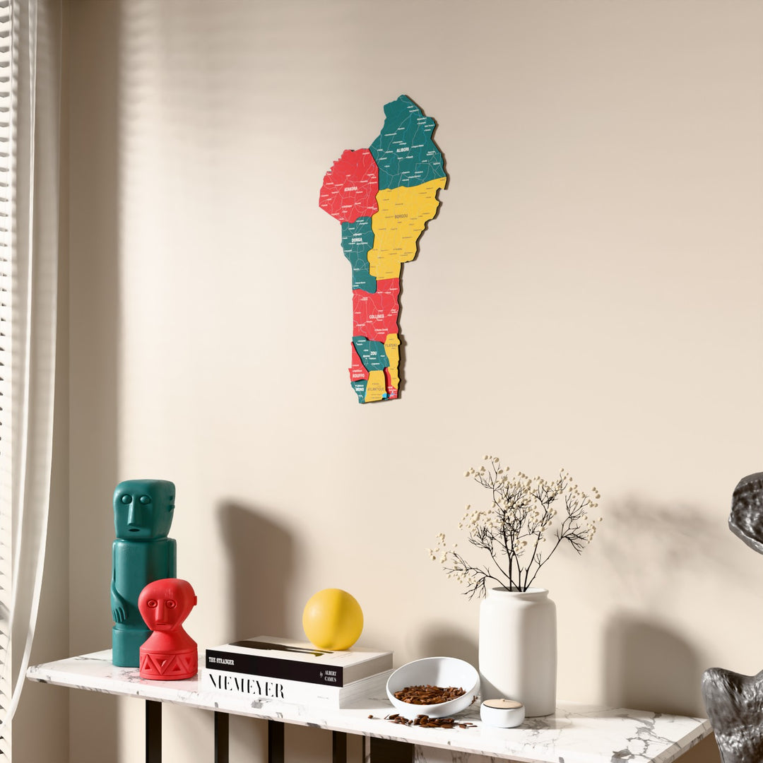 Flag colored Benin wooden wall map beside a sheer curtain, angled view