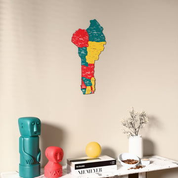 Flag colored Benin wooden wall map on a beige wall above a console with figurines