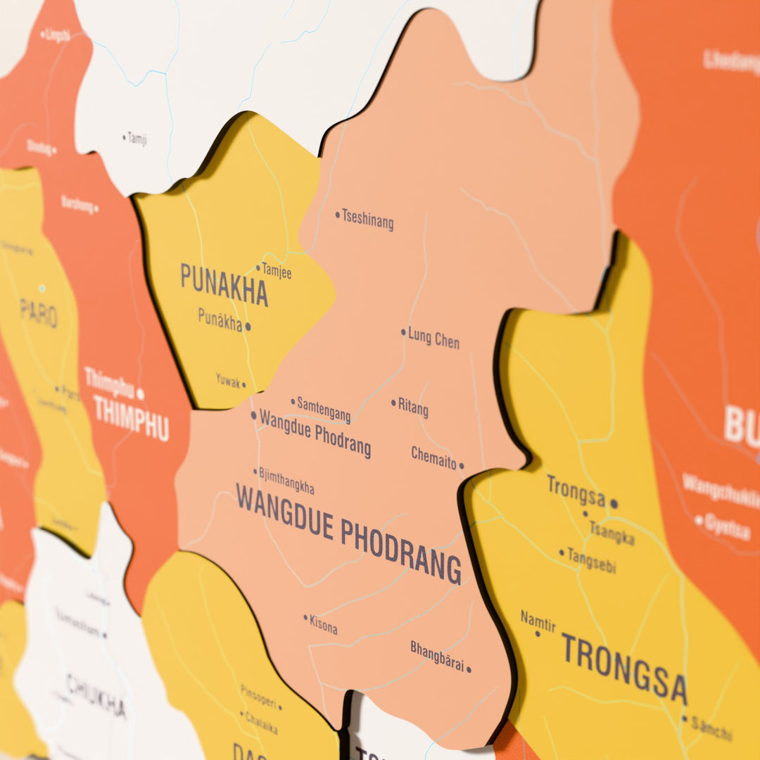 Close-up of the Flag colored Bhutan wooden wall map with layered regions and printed names