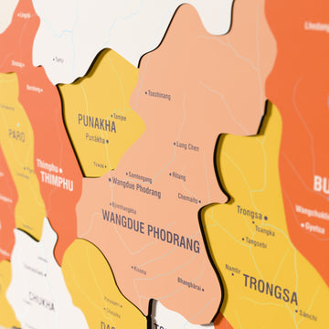 Close-up of the Flag colored Bhutan wooden wall map with layered regions and printed names