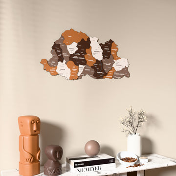 Soil Bhutan wooden wall map on a beige wall above a console with figurines