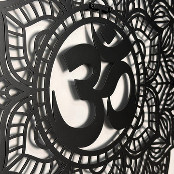 Close-up of the black OM mandala metal wall art showing the raised OM symbol and layered cutout petals