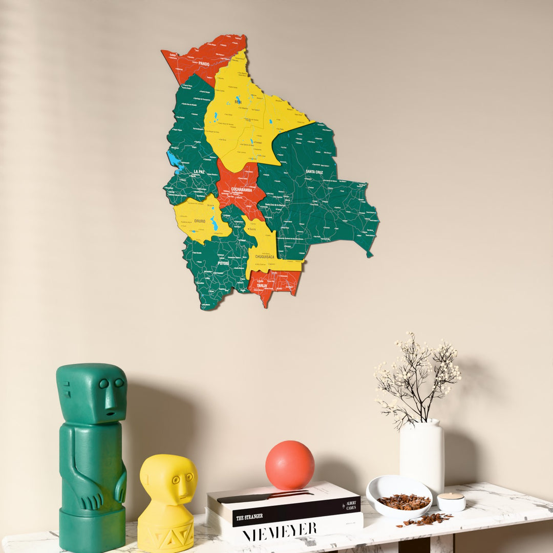 Flag colored Bolivia wooden wall map on a beige wall above a console with figurines