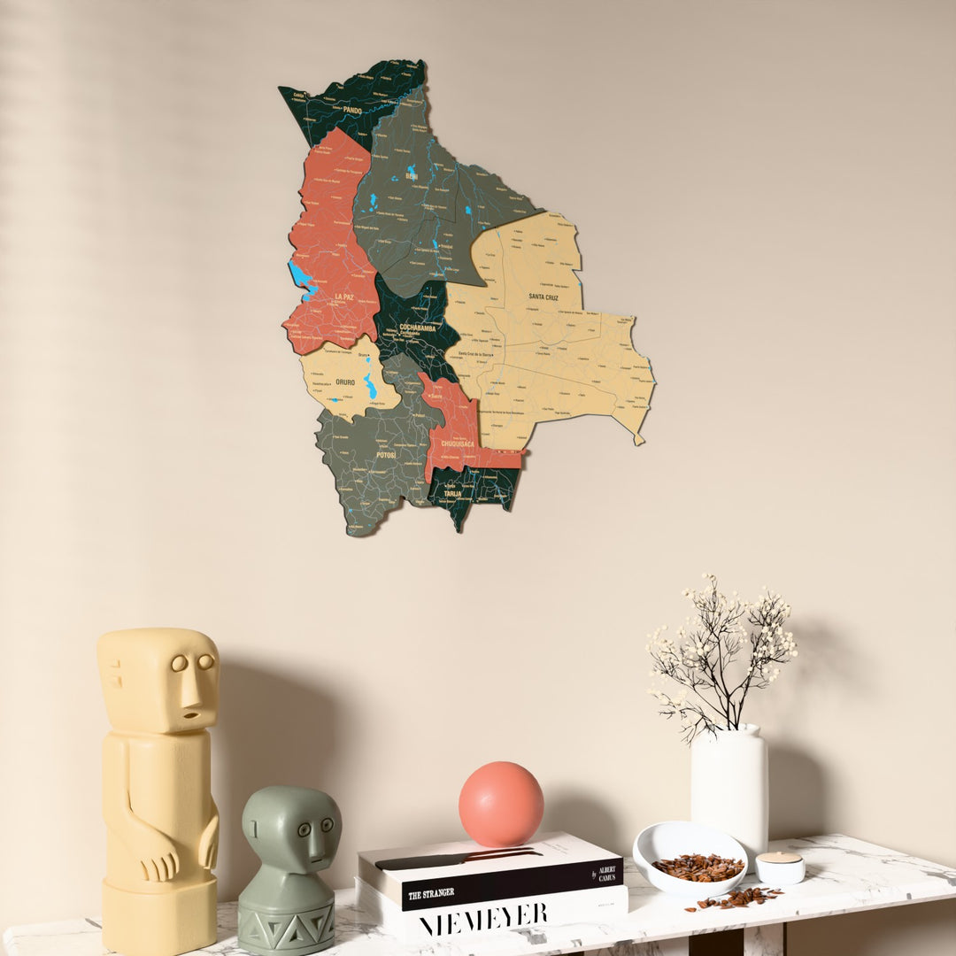 Sage Bolivia wooden wall map on a beige wall above a console with figurines