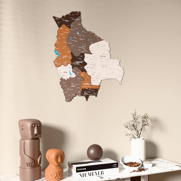 Soil Bolivia wooden wall map on a beige wall above a console with figurines
