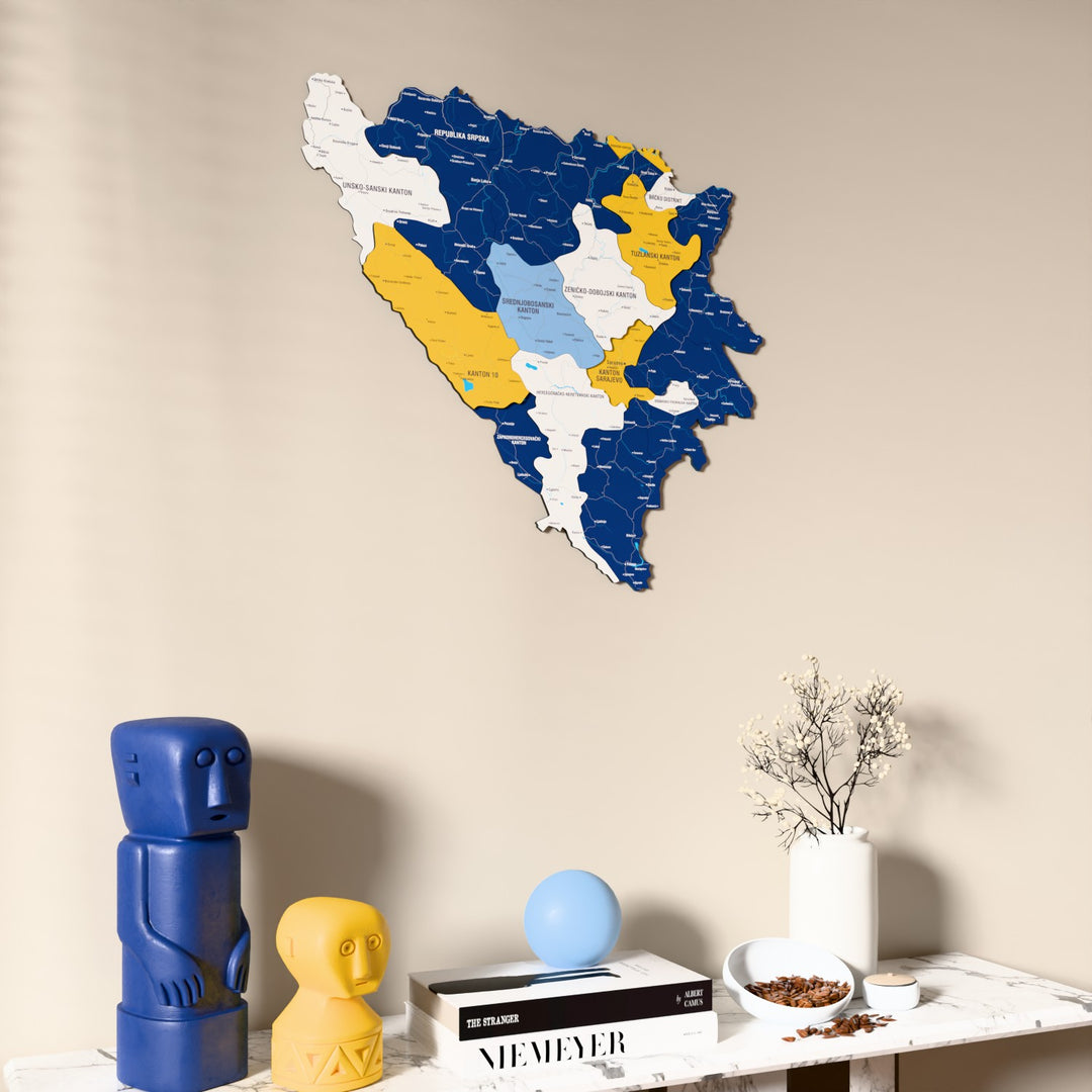 Flag colored Bosnia and Herzegovina wooden wall map on a beige wall above a console with figurines