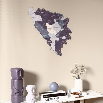Nimbus Bosnia and Herzegovina wooden wall map on a beige wall above a console with figurines