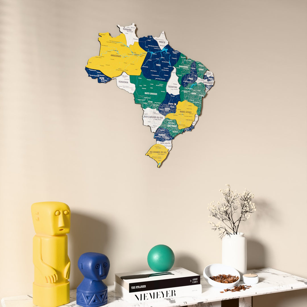 Flag colored Brazil wooden wall map on a beige wall above a console with figurines