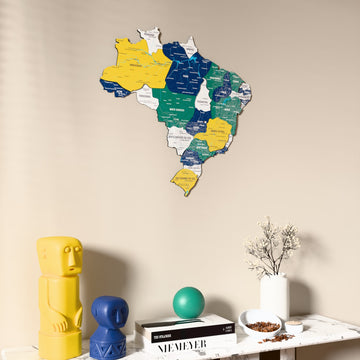 Flag colored Brazil wooden wall map on a beige wall above a console with figurines