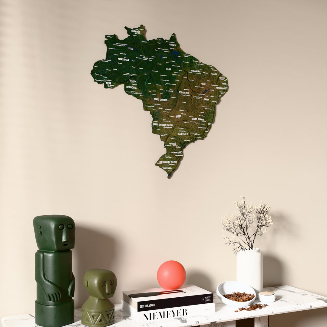 Satellite Brazil wooden wall map on a beige wall above a console with figurines