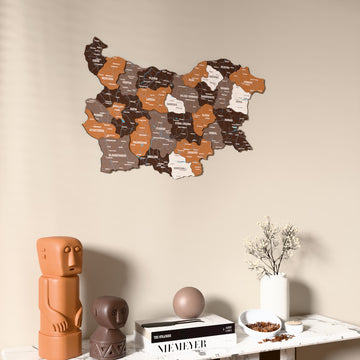 Soil Bulgaria wooden wall map on a beige wall above a console with figurines
