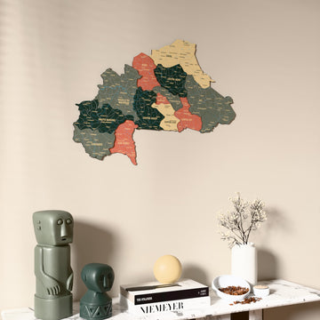 Sage Burkina Faso wooden wall map on a beige wall above a console with figurines
