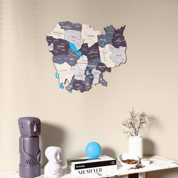 Nimbus Cambodia wooden wall map on a beige wall above a console with figurines