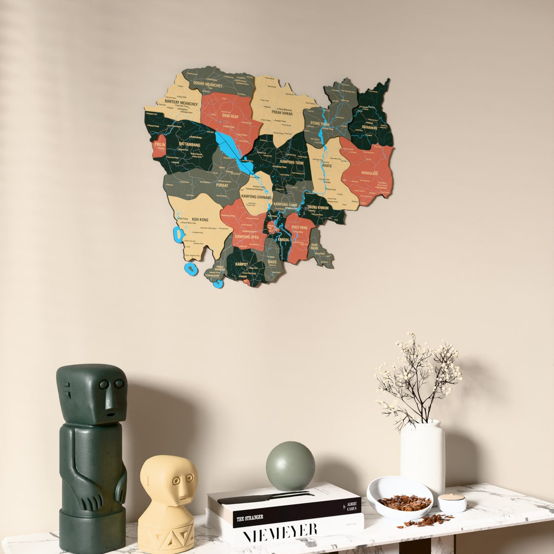 Sage Cambodia wooden wall map on a beige wall above a console with figurines