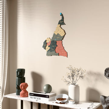 Sage Cameroon wooden wall map beside a sheer curtain, angled view