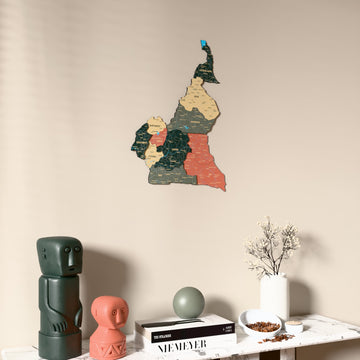 Sage Cameroon wooden wall map on a beige wall above a console with figurines