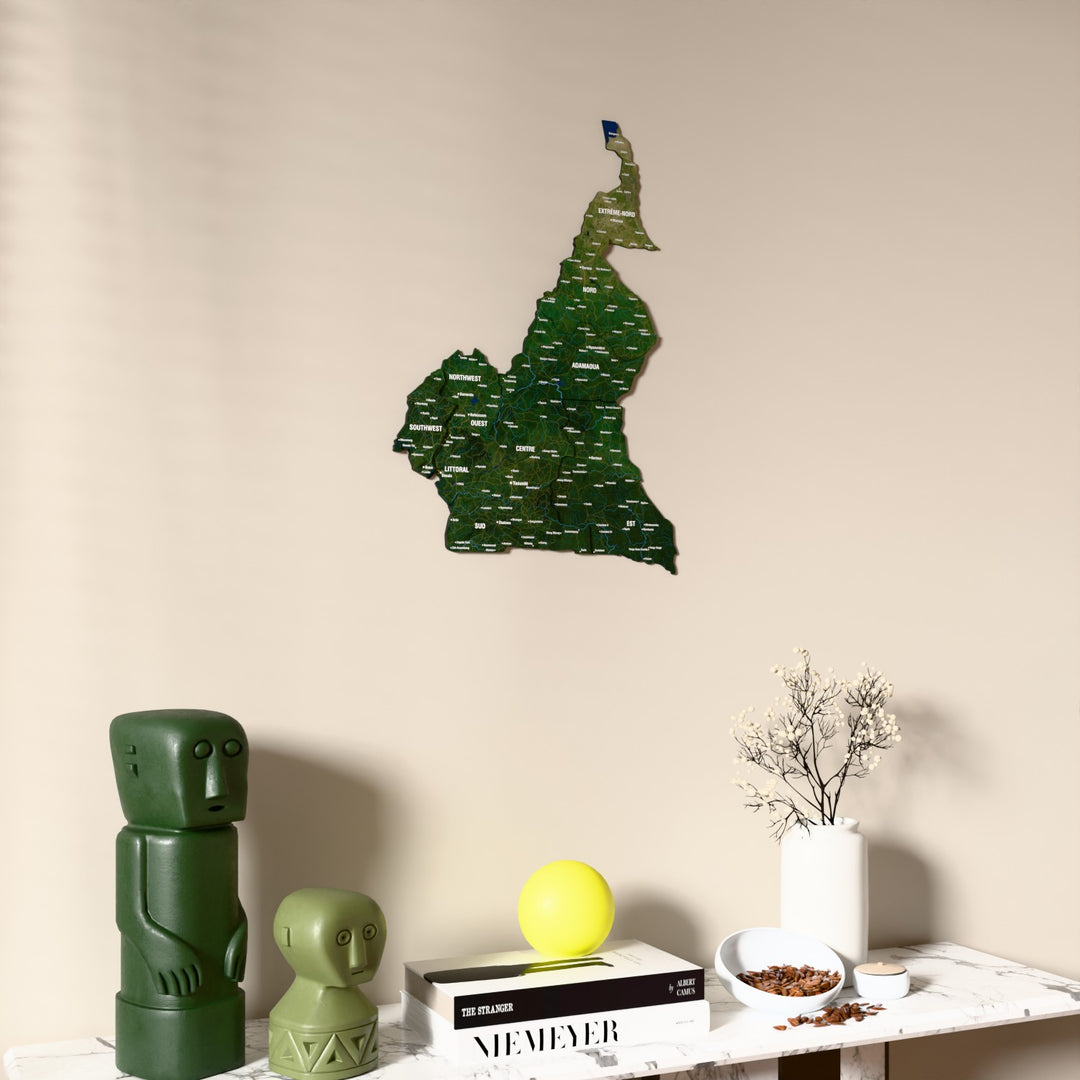 Satellite Cameroon wooden wall map on a beige wall above a console with figurines
