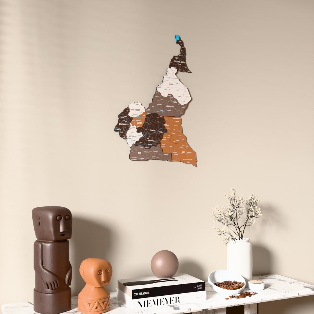 Soil Cameroon wooden wall map on a beige wall above a console with figurines