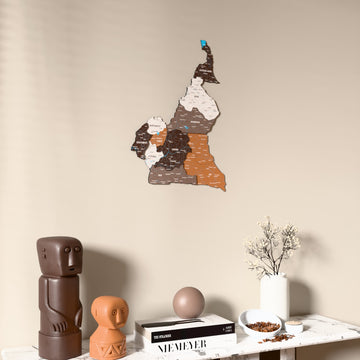 Soil Cameroon wooden wall map on a beige wall above a console with figurines