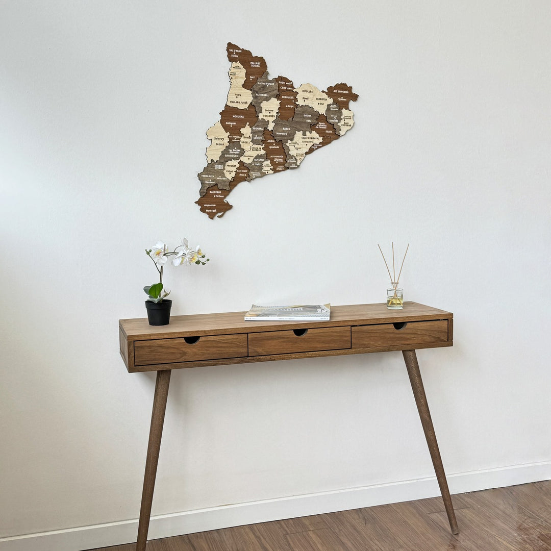Wooden Catalonia map above a three-drawer console with an orchid, view from the right