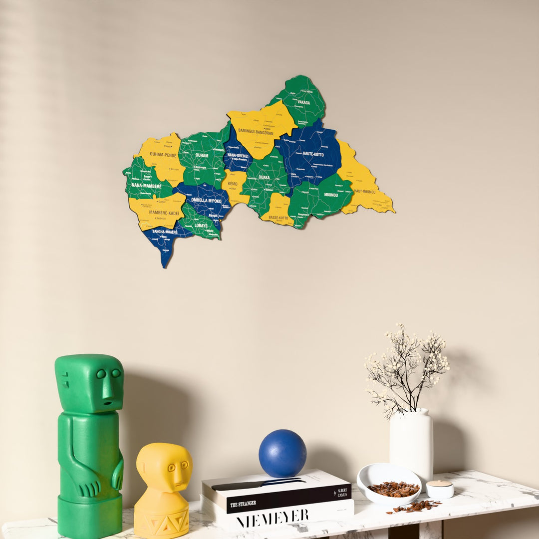 Flag colored Central African Republic wooden wall map on a beige wall above a console with figurines
