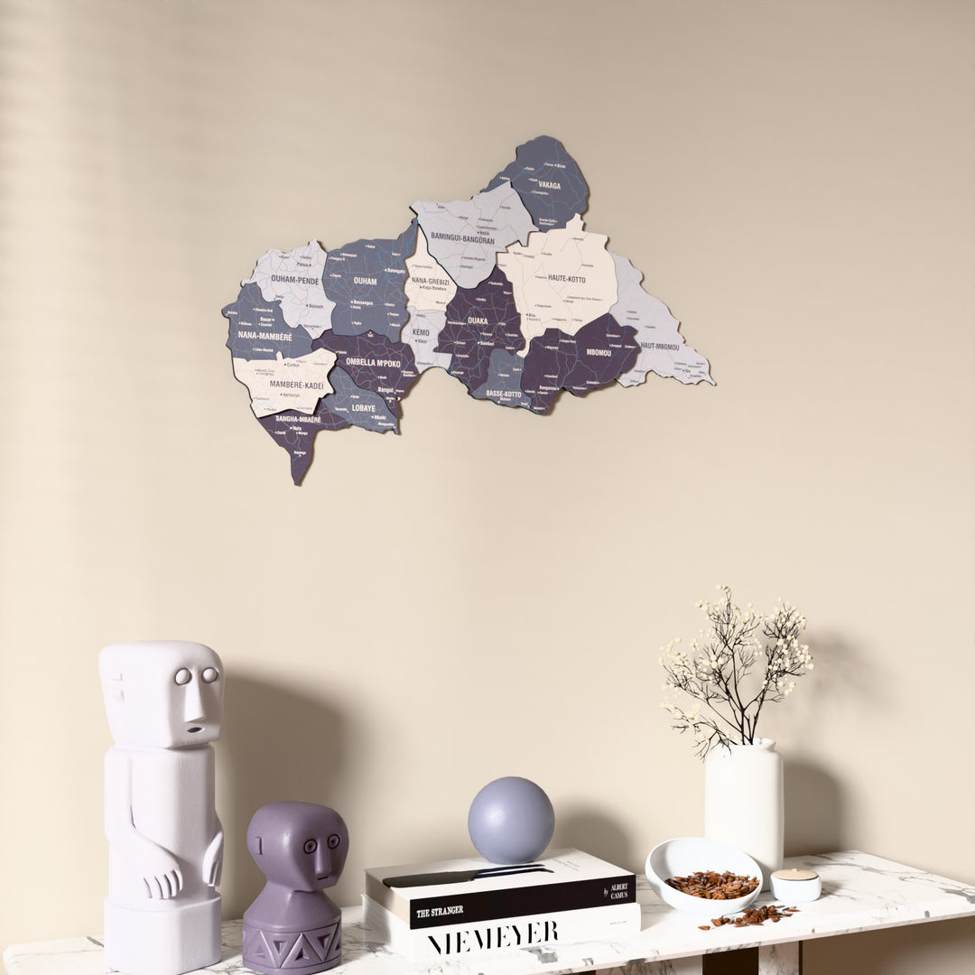 Nimbus Central African Republic wooden wall map on a beige wall above a console with figurines