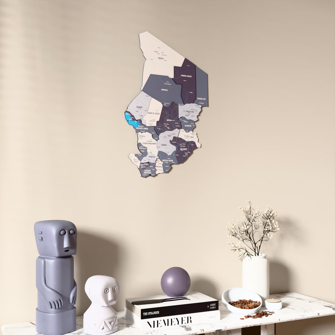 Nimbus Chad wooden wall map on a beige wall above a console with figurines