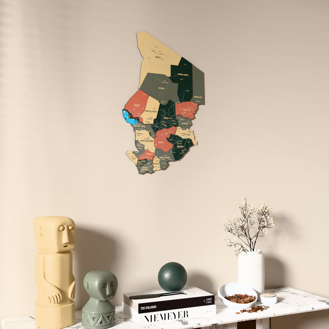 Sage Chad wooden wall map on a beige wall above a console with figurines