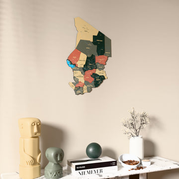 Sage Chad wooden wall map on a beige wall above a console with figurines