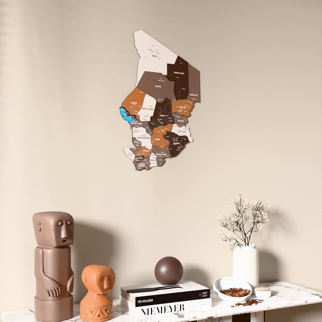 Soil Chad wooden wall map on a beige wall above a console with figurines