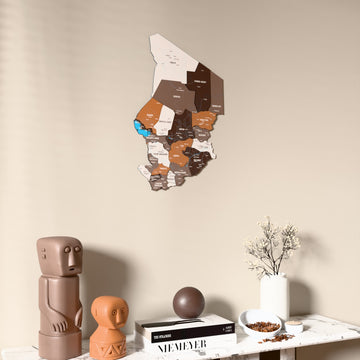 Soil Chad wooden wall map on a beige wall above a console with figurines