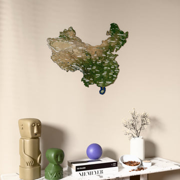 Satellite China wooden wall map on a beige wall above a console with figurines