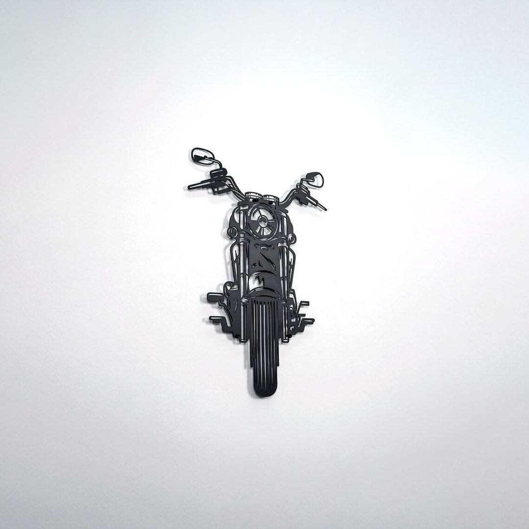 Black chopper motorcycle metal wall art on a white wall, wide shot